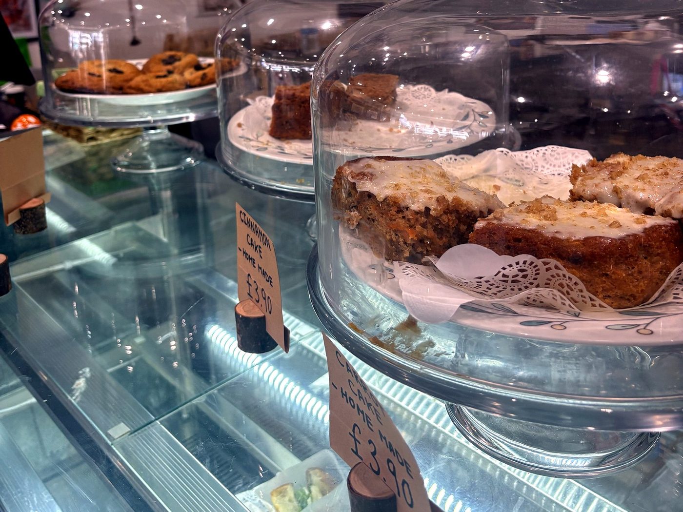 Mum's homemade carrot cake and cinnamon cake under glass domes on the counter
