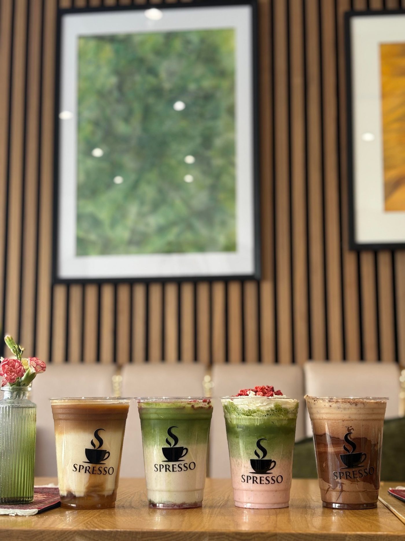 Four Spresso iced drinks lined up on a wooden table in the café