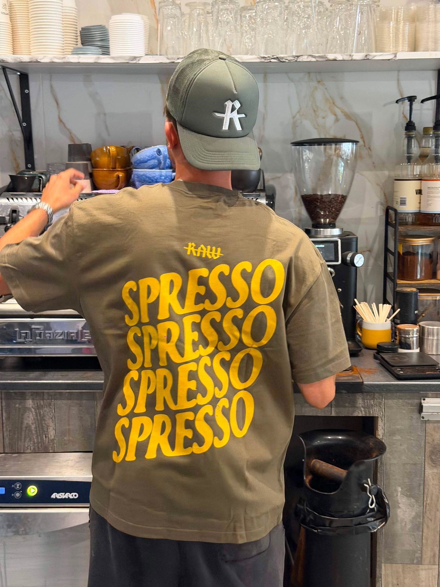 Barista in a Spresso t-shirt at the coffee machine