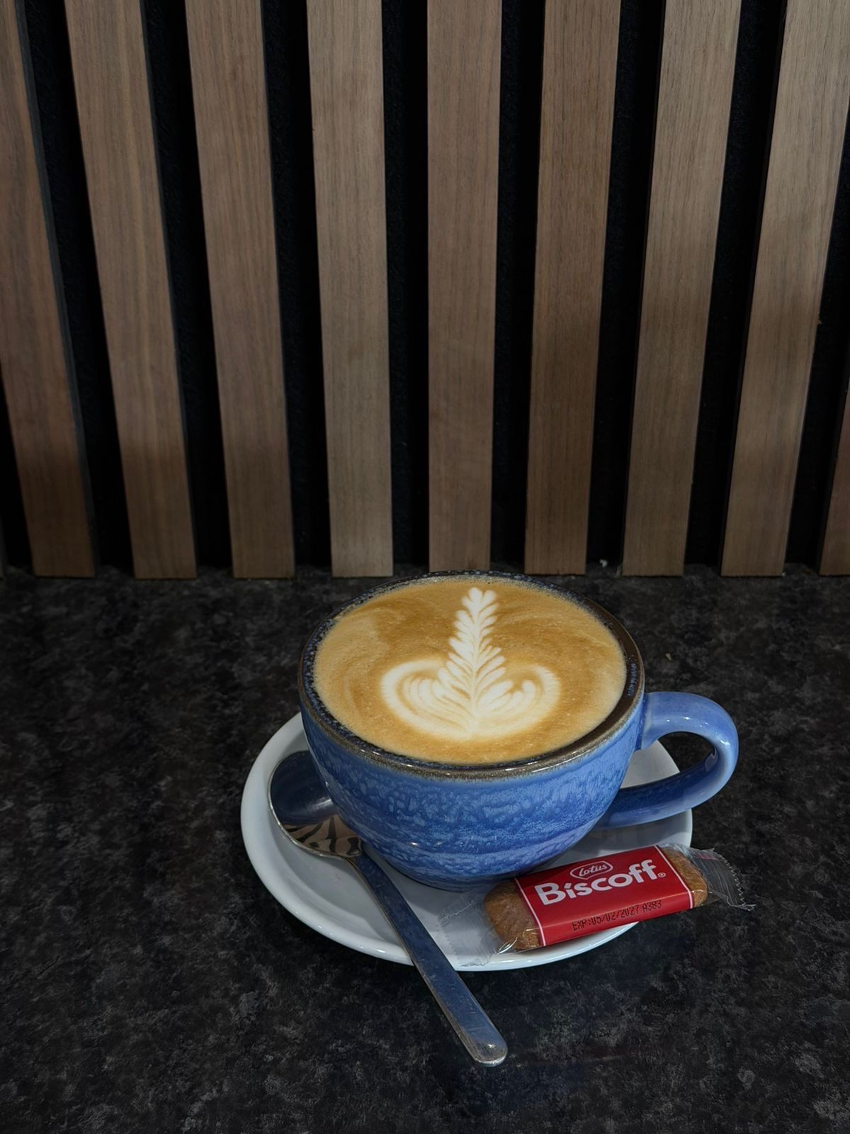 Latte with rosetta latte art in a blue cup